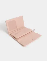 Billetera color rosa pálido con estampado de flores pequeñas, formato fichero con solapa y tag en relieve. Tiene cierre superior con puller, solapa con broche, compartimento para tarjetas y bolsillo interno con solapa.