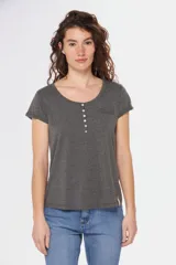 Remera color beige con escote redondo, manga corta, bolsillo en el pecho y cierre parcial con botones.