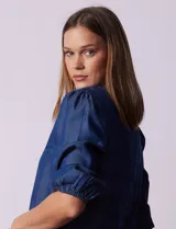 Blusa de lyocell azul, marca Alex & Parker, con cuello a la base y escote en V. Manga ¾ con terminación fruncida.