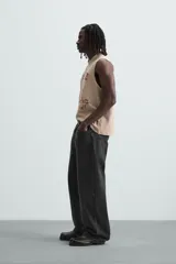 Camiseta sin mangas color beige con estampado de caballos en color borgoña.