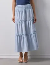 Falda midi a rayas verticales celestes y blancas, con pretina ancha elastizada en punto smock y volados en los cortes.