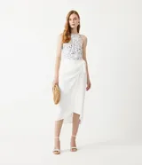 Musculosa blanca con estampado de peces azules, cuello halter con detalle de cuerda y sisa americana.