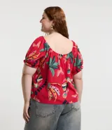 Blusa plus size con mangas cortas abullonadas y elástico en los hombros. Prenda confeccionada en viscolino y estampada con motivos de follajes y tucanes.