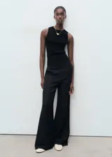 Musculosa negra de tejido de punto fino, con cuello redondo y tirantes anchos.