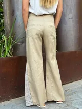 Pantalón de lino color tostado con detalles de crochet en los laterales.