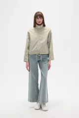 Campera de corte holgado en color tostado, confeccionada en poliamida. Presenta cuello alto, cierre frontal con cremallera, bolsillos laterales con cierre y cordón ajustable en el ruedo.