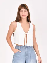 Chaleco blanco con calados y lazo en el frente.