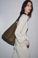 Camiseta blanca de manga larga con cuello redondo y detalle de encaje en el ruedo y puños.