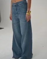 Pantalón de jean celeste de corte ancho con cintura alta y ruedo desflecado.