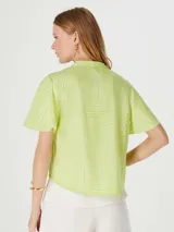 Blusa verde con estampado geométrico blanco, cuello en V y mangas cortas amplias.