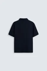 Polo azul marino de corte regular, con cuello solapa y cierre frontal de botonadura.