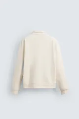 Sudadera regular fit color bordó, con cuello alto y cierre frontal de cremallera. Manga larga y acabados en rib.