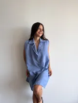 Vestido celeste sin mangas con cuello camisero y abotonadura frontal.