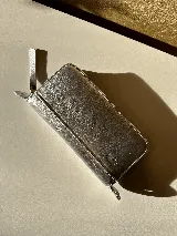 Billetera grande de cuero color verde oliva con correa de hombro desmontable. Tiene espacio para tarjetas, billetes, documentos y un bolsillo con cierre.