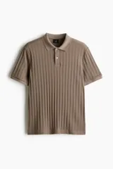 Remera polo marrón en punto texturizado de peso medio, de manga corta con cuello, tapeta de botones y bajo recto. Corte ajustado que realza el contorno del cuerpo creando una silueta entallada.
