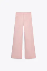 Pantalón de jean color rosa, de tiro alto, corte recto y largo hasta el tobillo. Presenta bolsillos de parche delanteros y traseros, trabillas en la cintura y cierre frontal con cremallera y botón.