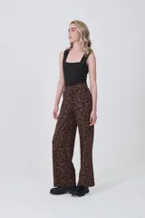 Pantalón de tiro alto, corte recto y largo, con estampado de lunares blancos sobre fondo negro.