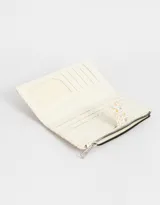 Billetera de cuerina con estampado de flores y diseño de cachemira. Tiene formato de fichero con sistema de apertura con broche a presión y cierre superior.