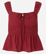 Blusa texturizada color borgoña, con breteles anchos, escote cuadrado, lazo en el busto y volado en el ruedo.