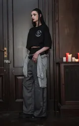 Remera negra de manga corta y cuello redondo, con calce oversize. Presenta una estampa sublimada inspirada en el tarot, con la imagen de una mujer de cabello azul con estrellas, tres espadas y rosas moradas, y la frase "3 DE ESPADAS" en una cinta.