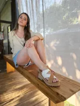 Sandalia de cuero color crudo con tiras cruzadas y cierre en el talón.