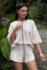 Top de punto crochet color crudo con mangas cortas y cuello redondo.