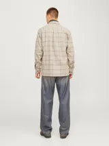 Sobrecamisa beige a cuadros con dos bolsillos frontales con botón, de manga larga y corte recto.