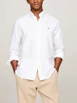 Camisa blanca de algodón Oxford con cuello abotonado, mangas largas y logo de Tommy Hilfiger bordado en el pecho. Corte regular.