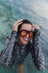 Vestido corto de lentejuelas negras translúcidas con mangas largas.