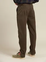 Pantalón de vestir color beige con pinzas, bolsillos laterales y traseros. El ruedo tiene un pequeño corte lateral.