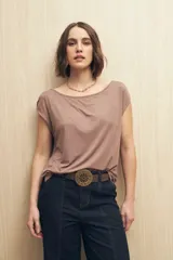 Remera color marrón claro de modal con cuello bote, manga corta y frunces en los hombros.