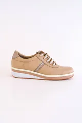 Zapatillas deportivas acordonadas color beige con suela de plataforma blanca y detalles en color plata.