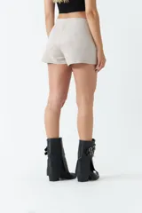 Short falda color marrón de gamuza con corte asimétrico y cierre invisible lateral.