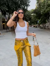 Pantalón acampanado de cuero sintético con estampado de piel de serpiente en tonos azules.