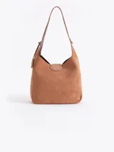 Cartera tipo hobo color marrón oscuro con efecto gastado, confeccionada en cuero vacuno. Tiene un asa de hombro, cierre de torniquete metálico y un sobre interno extraíble.