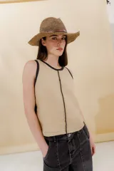 Musculosa color beige con terminaciones en negro, bordada a mano con técnica mixta.