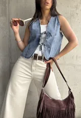 Chaleco de denim celeste con lazo frontal y corte al cuerpo.