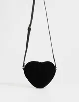 Bandolera negra en forma de corazón, confeccionada en cuerina acolchada con pespuntes verticales. Tiene correa larga regulable y cierre superior.