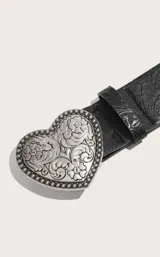 Cinturón negro con estampado floral y hebilla metálica plateada en forma de corazón con detalles florales grabados.