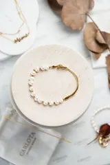 Pulsera dorada de acero quirúrgico con perlas de agua dulce.