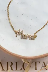 Collar dorado con dije de la palabra 'Mamá' con incrustaciones de circonitas blancas.