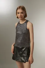 Musculosa negra con lentejuelas plateadas, cuello redondo y corte recto.
