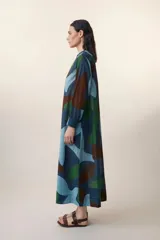 Vestido largo de verano de algodón con estampado abstracto en tonos azul, verde y marrón. Presenta cuello mao, pechera con botones y corte evasé.