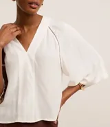 Blusa verde con escote en V, mangas cortas amplias y sisas con entremedios. Confeccionada en viscolino texturizado.