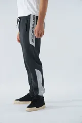 Pantalón de jogging gris oscuro de felpa con puños, cintura ajustable con cordón y logo estampado en la pierna.
