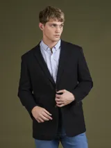 Blazer azul marino de corte clásico con solapa de muesca, cierre de dos botones y bolsillos laterales con solapa.