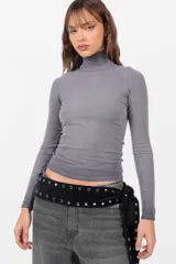 Top gris de morley con cuello alto, manga larga y corte ajustado. Tiene teñido degradado en los bordes.