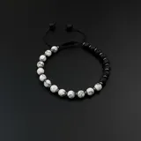 Pulsera elástica con cuentas de piedra volcánica negra y piedra blanca veteada.