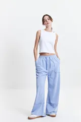 Pantalón de felpa celeste con cintura elastizada ajustable y bolsillos laterales.