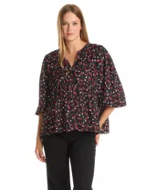Blusa de gasa estampada en color negro con motivos rojos y blancos, de cuello a la base con escote en V y manga larga con terminación fruncida.